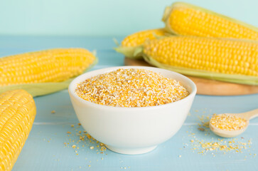Corn groats with fresh cobs on wooden table