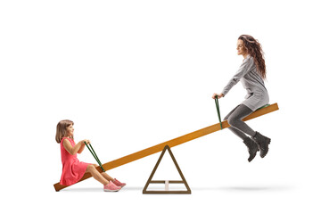 Young woman playing on a seesaw with a child
