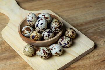 quail eggs in wooden bowl.