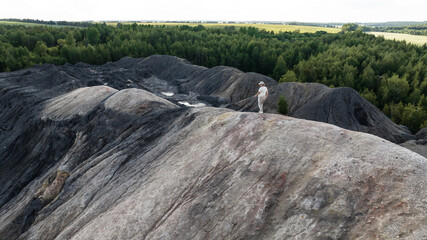 a panoramic view of the high hills of a woman walking on a slope and a green forest from a nature reserve in the Tula region taken from a drone