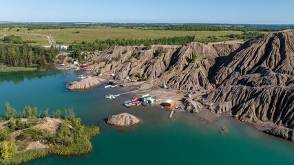 panoramic view of the high hills of the lake with turquoise water and green forest from the reserve in the Tula region taken from a drone