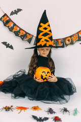 Happy child girl in witch costume playing with beetles and insects on halloween party. lantern jack, happy halloween. autumn concept. High quality photo
