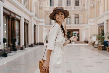 attractive woman walking in shopping street in Italy on vacation dressed in white summer fashion...