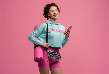 smiling happy beautiful woman in stylish sports outfit posing on pink background isolated in studio