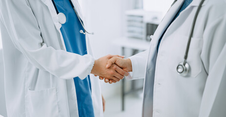 Doctor, handshake and partnership in healthcare, medicine or trust for collaboration, unity or support.Team of medical experts shaking hands in teamwork for or success in clinic or hospital