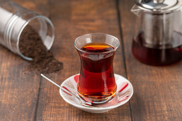 Freshly brewed turkish tea in thin-waisted glass cup on wooden table