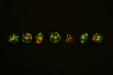 green and yellow colours dices for fantasy dnd and rpg tabletop games. Board game polyhedral dices with different sides isolated on black background