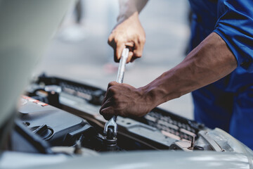 Professional mechanic checking and repairing a car. Auto mechanic working in garage. Repair service.