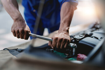 Professional mechanic checking and repairing a car. Auto mechanic working in garage. Repair service.