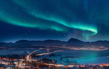 Naklejka na ściany i meble Aurora borealis or Northern lights in the sky over Tromso with Sandnessundet Bridge - Tromso, Norway