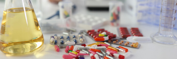 Tablets and yellow oil in a flask on a table in the laboratory