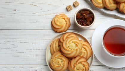 Delicious Danish butter cookies and tea on white wooden table, flat lay