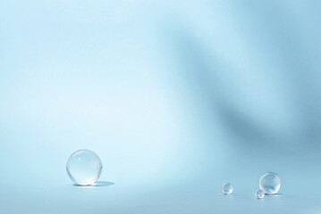 Blue background with transparent glass balls. Minimal concept and hard sunlight.
