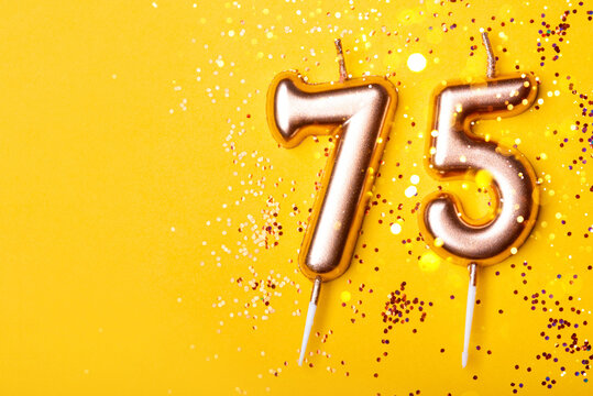 75 years celebration. Greeting banner. Gold candles in the form of number forty on yellow background with confetti.