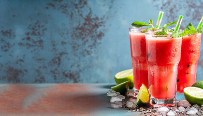 Watermelon slushie with lime, summer refreshing drink in tall glasses on a blue rusty background. with copy space