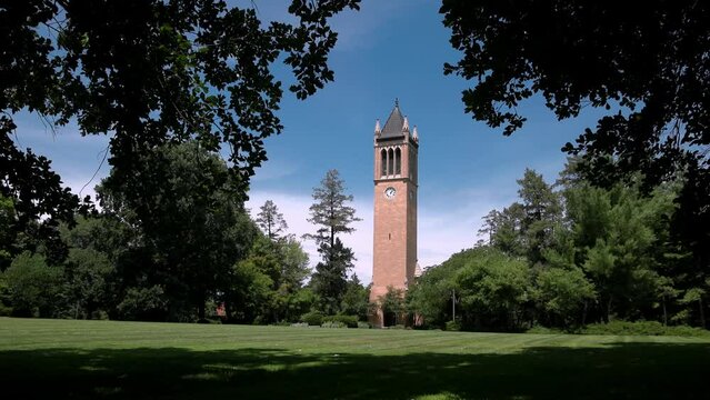 Iowa State University Campanile in Ames, Iowa with view through trees and lawn stable video.