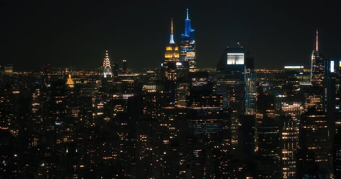 Aerial Footage of Office Buildings Late in the Evening. Rooms Have Lights On, Businesspeople and Managers Working Long Hours in New York City. Helicopter Cityscape View of Manhattanat Night