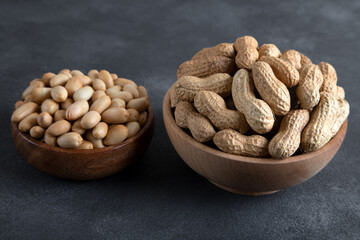 Bowl full of shelled and roasted peeled peanuts on black background,top view