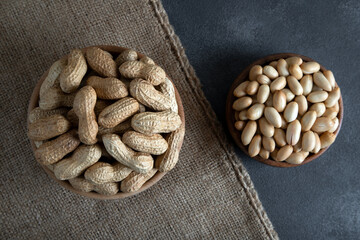 Bowl full of shelled and roasted peeled peanuts on black background,top view