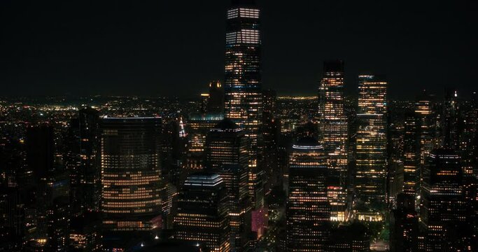 Aerial Helicopter Cinematic Night Scene with a Panoramic View with One World Trade Center Skyscraper and Vibrant Cityscape. Beautiful Office Buildings with Indoors Lights