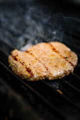 One chicken meat burger on grill