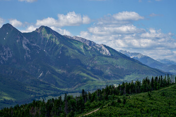 zdjęcie przedstawiające krajobraz górski wysokie szczyty i doliny nad którymi jest niebieskie...