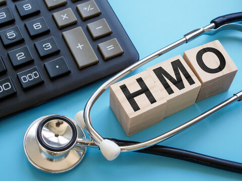 Stethoscope and cubes with letters HMO Health Maintenance Organization insurance.