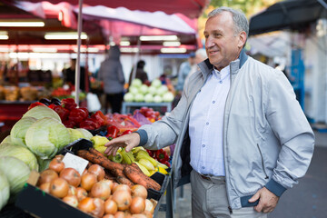 Middle aged man buying vegetables