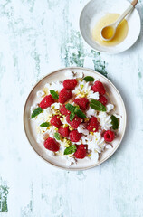 Raspberry, mascarpone and pavlova cookies dessert topped with honey and pistachios