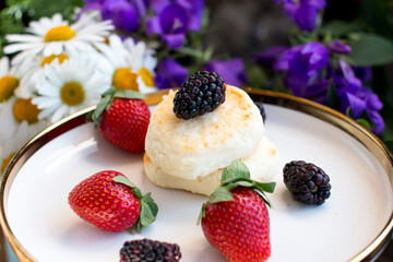 Morning breakfast with cheesecakes and strawberries and blackberries. Cooked breakfast is dietary and healthy