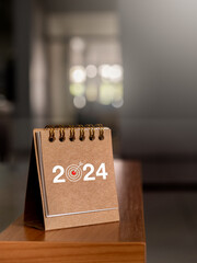 Happy new year 2024 banner background. 2024 numbers year with target icon on brown small desk...