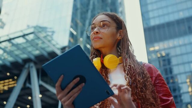 Young alternative multiethnic woman spending time in a modern part of the city. Female programmer going to work in the office