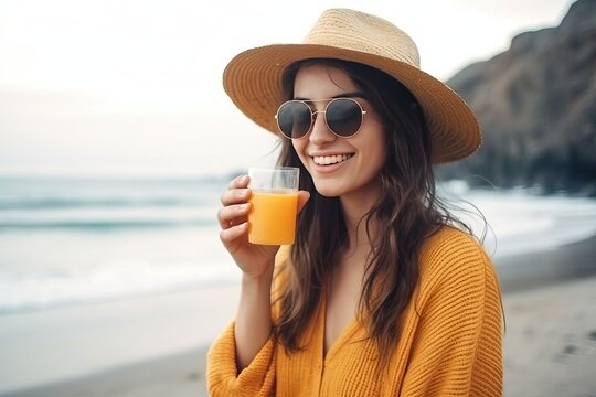 Summer drink, portrait of beautiful young woman drink orange juice at the beach