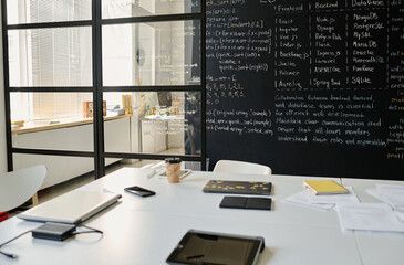 IT class with blackboard with information and computer device on table