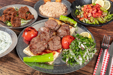 Turkish cuisine Meat Shish. Shish kebab prepared on a barbecue grill on hot coals with grilled vegetables. Grilled beef pieces on metal skewers.