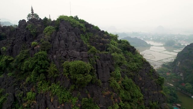 Vue a&eacute;rienne de Hang Mua &agrave; Ninh Binh au Vietnam, paysage karstique avec grotte, escalier et pagode sur la montagne du dragon couch&eacute;, culture et nature dans la baie d&rsquo;Halong terrestre.