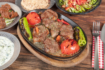 Turkish cuisine Meat Shish. Shish kebab prepared on a barbecue grill on hot coals with grilled vegetables. Meat skewers cooked in butter and stew.