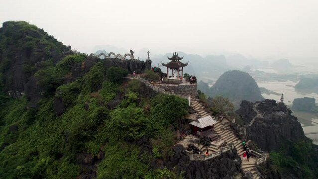 Vue a&eacute;rienne de Hang Mua &agrave; Ninh Binh au Vietnam, paysage karstique avec grotte, escalier et pagode sur la montagne du dragon couch&eacute;, culture et nature dans la baie d&rsquo;Halong terrestre.