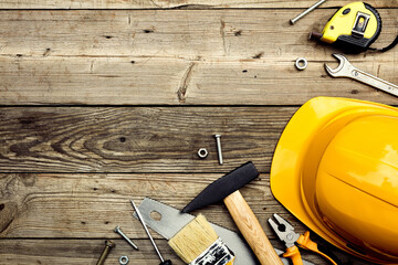 Construction tools with safety helmet on wooden background. Happy Labor day banner design.