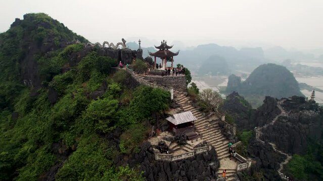 Vue a&eacute;rienne de Hang Mua &agrave; Ninh Binh au Vietnam, paysage karstique avec grotte, escalier et pagode sur la montagne du dragon couch&eacute;, culture et nature dans la baie d&rsquo;Halong terrestre.