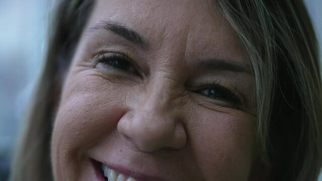 Macro close-up of a happy mature woman smiling at camera, a female caucasian 50s person joyful emotion