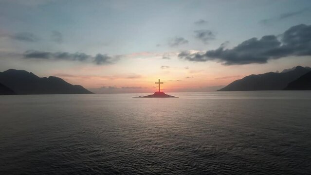 Christ Cross on an island in the middle of the open sea. Looping animation concept for faith, power, worship, christianity and easter