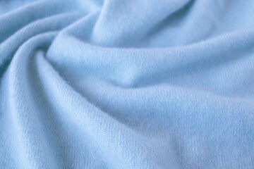 Blue cashmere fabric, textile is folded, knitwear texture, natural fabric, top view - obrazy, fototapety, plakaty