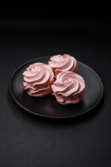 Delicious sweet colored marshmallow on a dark concrete background