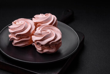 Delicious sweet colored marshmallow on a dark concrete background