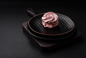 Delicious sweet colored marshmallow on a dark concrete background