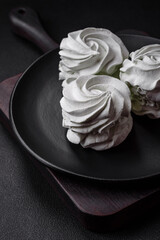 Delicious sweet colored marshmallow on a dark concrete background