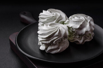 Delicious sweet colored marshmallow on a dark concrete background