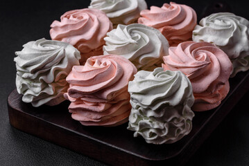 Delicious sweet multi-colored marshmallow on a dark concrete background