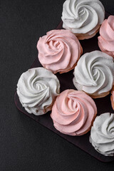 Delicious sweet multi-colored marshmallow on a dark concrete background